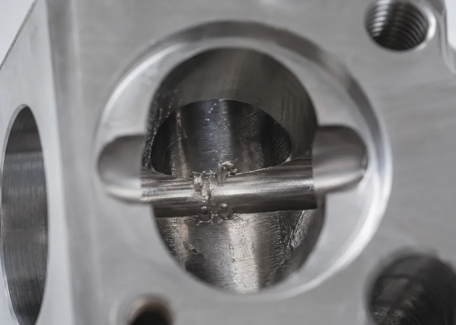 Why Are Stainless Steel CNC Parts Prone to Tight Tapped Holes, Burrs and Thread Galling? 7 burrs inside cross-drilled holes on a stainless steel CNC machined part